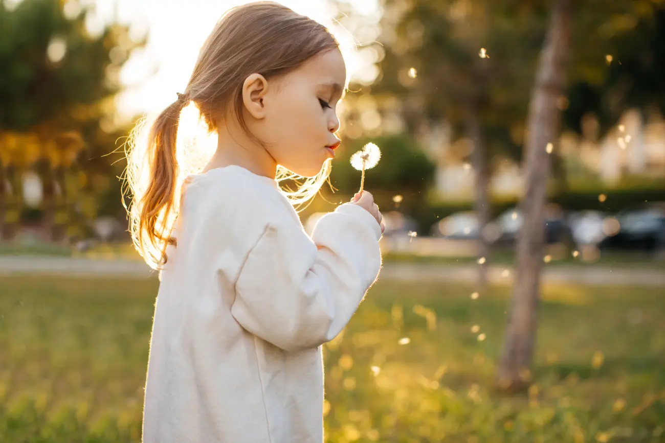 Una niña sosteniendo una flor en el exterior